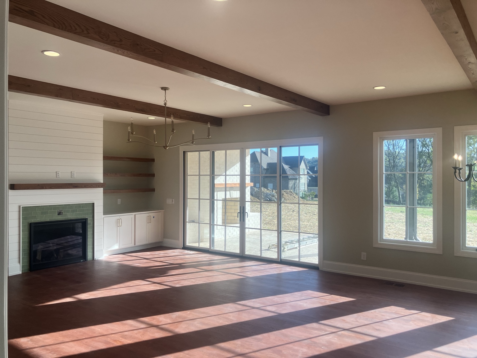 Finished custom living room with wood beams and fireplace